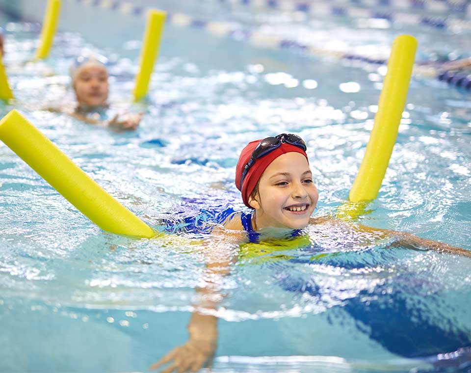 Kind schwimmt mit Schwimmhilfe 